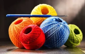 Ovillos de hilo de colores y aguja de crochet listos para tejer crochet